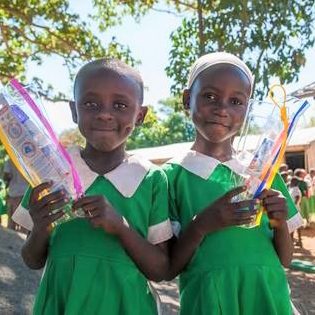 Dala Development - Students with kits of a toothbrush, paste, floss, and a toothbrush cover